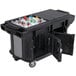 A black Cambro Versa Ultra work table with heavy duty casters and a large cooler filled with bottles.