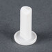 A white plastic object with a round base.