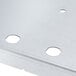 A white oval metal plate with a white circle and black border with holes in it.