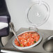 A clear plastic bowl with a Steril-Sil hinged lid on a bowl of food with a spoon.