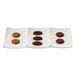 A white CAC porcelain rectangular plate divided into three sections with a group of chocolate cookies on one section.