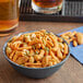 A bowl of Fiesta Sunshine Snack Mix on a table in a cocktail bar.