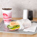 Durable Packaging deli sheets wrapped around a sandwich on a tray with a drink.