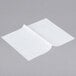 Durable Packaging white interfolded deli sheets on a gray surface.
