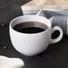 A white Diamond mug filled with coffee on a table.