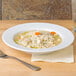 A CAC super white porcelain soup bowl with rice and vegetables.