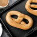 A PretzelHaus cinnamon sugar pretzel on a black tray.