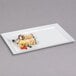 A white rectangular melamine display tray with food on it.