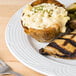 A CAC porcelain plate with chicken, broccoli, and mashed potatoes on a wood table.