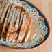 A GET Bella Fresco melamine oval platter with sliced bread on it.