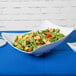 A salad in a white San Michele melamine bowl.