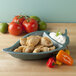 A HS Inc. Jalapeno Peppertizer bowl filled with food next to tomatoes and peppers.