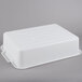 A white rectangular Vollrath perforated drain box with handles.