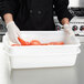 A person using a Vollrath perforated drain box to hold tomatoes.