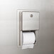 A stainless steel Bobrick multi roll toilet paper dispenser with a roll of toilet paper.