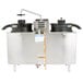 A stainless steel Bunn high volume coffee machine urn with black lids and wheels.