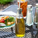 A Tablecraft green glass oil and vinegar dispenser on a table.