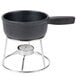 An American Metalcraft stainless steel stand with a candle holding a black cast iron fondue pot.