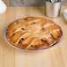 A pie in a Vollrath aluminum pie pan on a table.