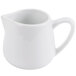 A white porcelain creamer with a handle.