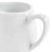 A close up of a white CAC porcelain creamer with a handle.