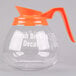 A Grindmaster glass coffee decanter with an orange decaf handle.