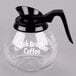 A Grindmaster glass coffee decanter with a black handle.