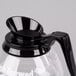 A Grindmaster coffee decanter with a black handle.