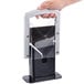 A hand holding a Larien Commercial Plus Bagel Biter bagel slicer with a black handle.
