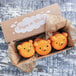 A box of cookies with a Durable Packaging green unbleached brown soy wax bakery tissue on a counter.
