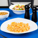 A table with a plate of pasta and salad served in a CAC Camptown pasta bowl.