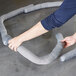 A person using a Spilfyter absorbent sock to clean up a spill on the floor.