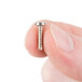 A person holding a small silver Waring screw.