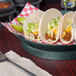 A plate of tacos with a HS Inc. round deli server filled with jalapenos on a table.