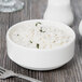 A Homer Laughlin bright white china bowl filled with rice on a table.