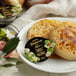 A plate with two crumpets and a Dickinson's Pure Honey portion cup on a table.