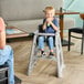 A gray Rubbermaid restaurant high chair without wheels, designed for children.