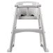 A white Rubbermaid restaurant high chair with a white plastic seat.