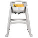 A grey plastic Rubbermaid high chair with a yellow warning label.