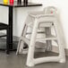 A Rubbermaid plastic high chair next to a table.