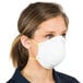 A woman wearing a Cordova N-95 particulate respirator with a yellow band.