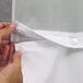 A person holding a white Hookless shower curtain with a white voile window.