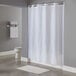 A white Hookless pin dot shower curtain hanging in a bathroom.