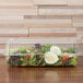 A Polar Pak clear hinged takeout container filled with salad including lettuce, cucumbers, and fruit.