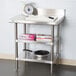 A Regency stainless steel work table with a measuring scale on top.