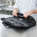 A chef holding a Victorinox black bag with a knife set.