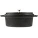 An American Metalcraft pre-seasoned black cast iron oval Dutch oven with a lid.