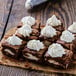 A brownie with white frosting piped in an open star pattern on top.