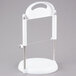 A white plastic stand with a silver metal handle.