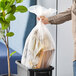 A person holding a Lavex plastic bag full of trash.